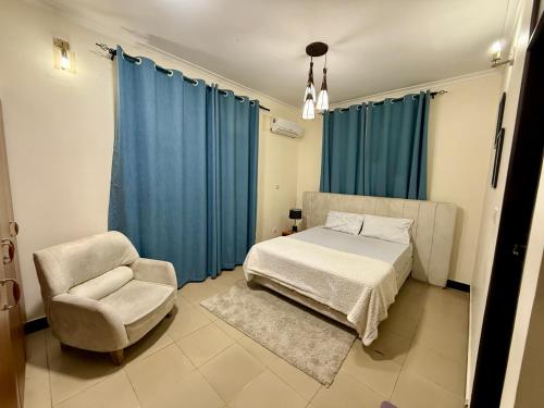 a bedroom with a bed and a chair at Jefes Haven in Dar es Salaam