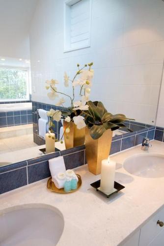 a bathroom with a sink and a vase with candles at Emerald Inn on Takapuna Beach in Auckland