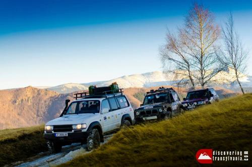 a group of three trucks parked on a hill at Cabana Haiducului in Teşila