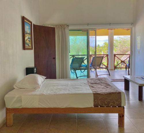 a bedroom with a bed and a balcony at Casa Del Sol in Lo de Marcos