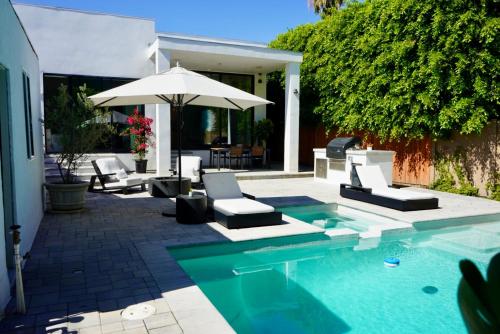 a swimming pool with lounge chairs and an umbrella at The Hollywood House in Los Angeles