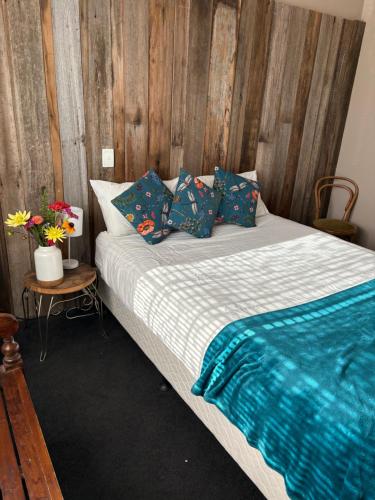 a bedroom with a bed with a wooden wall at The Bears in Geeveston