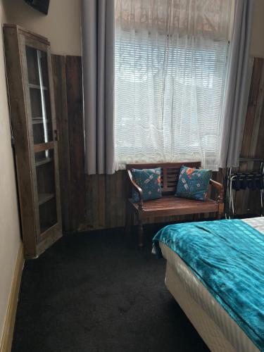 a bedroom with a bed and a window and a chair at The Bears in Geeveston