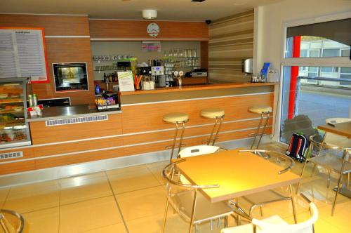 a restaurant with a counter with stools in front of it at GAS Truck centrum in Holíč