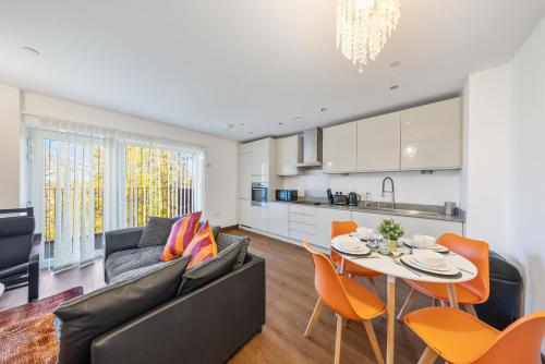 a living room with a couch and a table and chairs at Stylish long & short stay flat with parking & Wifi sleeps 5 in Maidstone