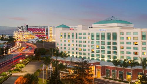 a large white building with a green roof on a city street at Hilton Santa Clara in Santa Clara