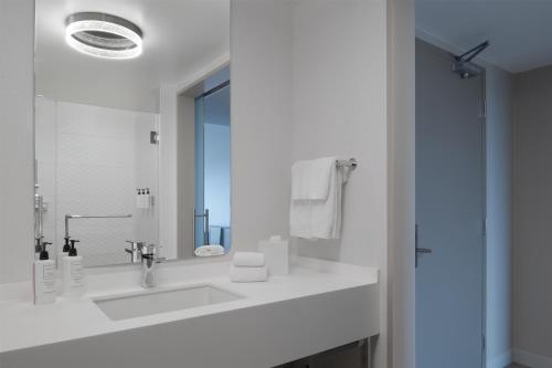 a white bathroom with a sink and a mirror at Hilton Santa Clara - Newly Renovated in Santa Clara