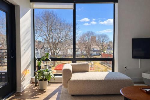 a living room with a chair and a large window at East Side Luxury 1BR Apt - Near Brady St with Balcony and Lounge - Sleeps 4 in Milwaukee