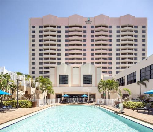 a hotel with a swimming pool in front of a building at Embassy Suites by Hilton Tampa Airport Westshore in Tampa