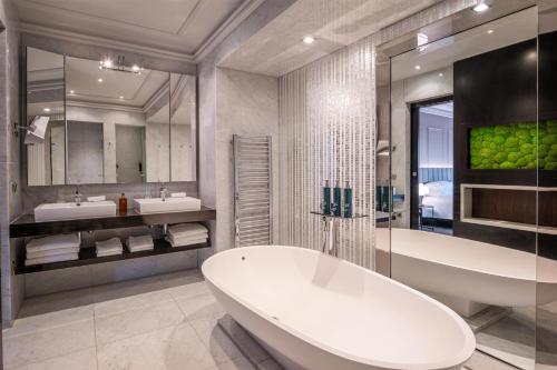 a bathroom with a tub and two sinks and a bath tub at Hilton Brussels Grand Place in Brussels