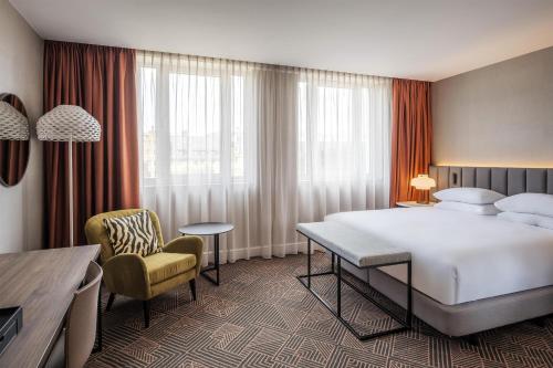 a hotel room with a large bed and a chair at Hilton Brussels Grand Place in Brussels