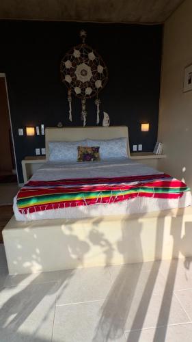 a white bed with a colorful blanket on it at Casa Jasmin Bed & Breakfast in Troncones