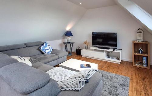 a living room with a couch and a flat screen tv at Kerarmoor in Plouhinec