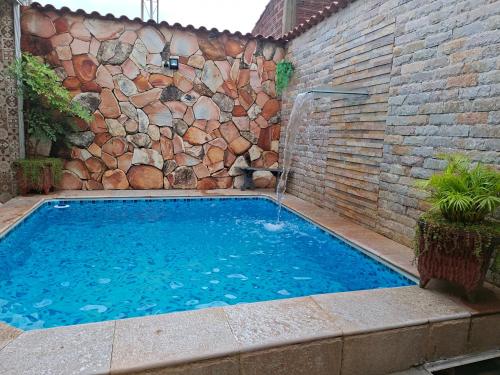 a swimming pool in front of a brick wall at Cantinho Abençoado in Pirenópolis