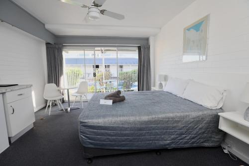 a bedroom with a bed with a teddy bear on it at Dalby Manor Motor Inn in Dalby