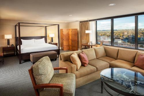 a hotel room with a couch and a bed at Doubletree By Hilton Billings in Billings