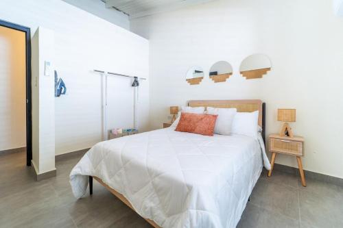 a bedroom with a large white bed and a mirror at Casa Norma in Mayaguez in Hacienda Constanza