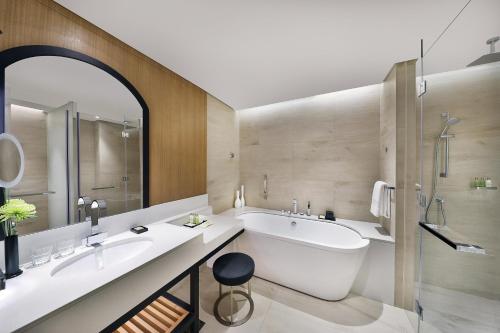 a bathroom with two sinks and a bath tub at DoubleTree by Hilton Dubai - Business Bay in Dubai