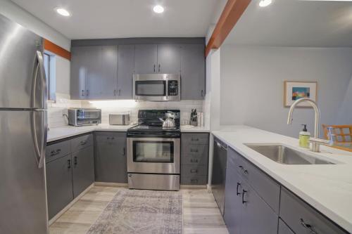 a kitchen with gray cabinets and stainless steel appliances at Lodge Condo 004 in Black Butte Ranch