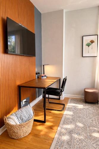 a room with a desk with a television and a chair at Flexhome Ukrainian Village - 2BR - Convenient Walkability in Chicago