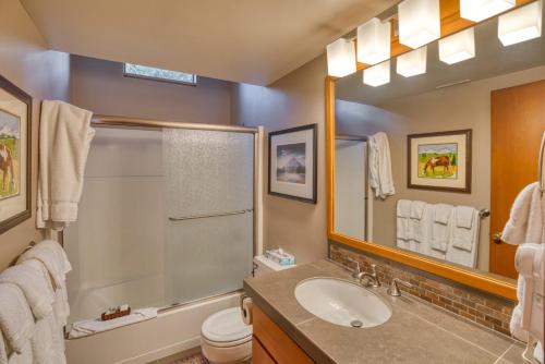 a bathroom with a sink and a toilet and a mirror at Lodge Condo 022 in Black Butte Ranch