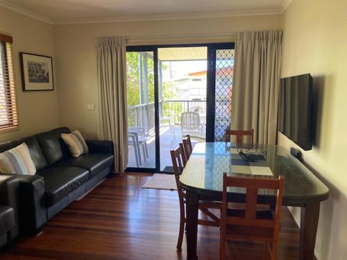a living room with a couch and a table with chairs at Alstan 3 Bedroom Beach House in Coolum Beach