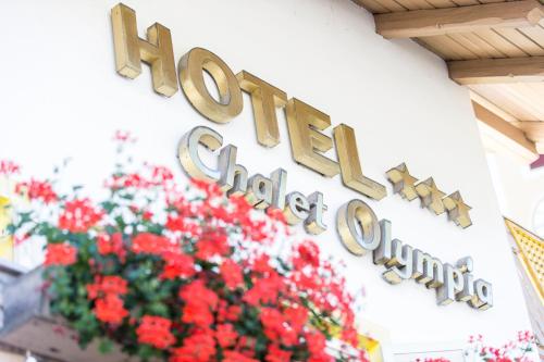 a sign for the houston disney store with red flowers at Hotel Chalet Olympia in Monguelfo