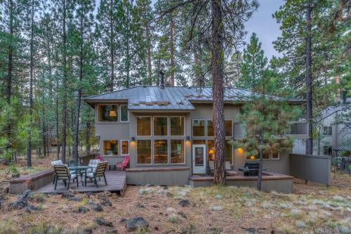 a house in the woods with a table and chairs at Rock Ridge 009 in Black Butte Ranch