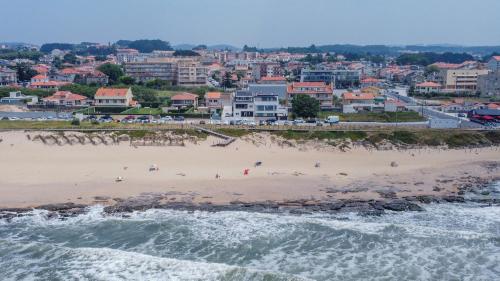 a view of a beach with a city in the background at Granja Beach Front in São Félix da Marinha