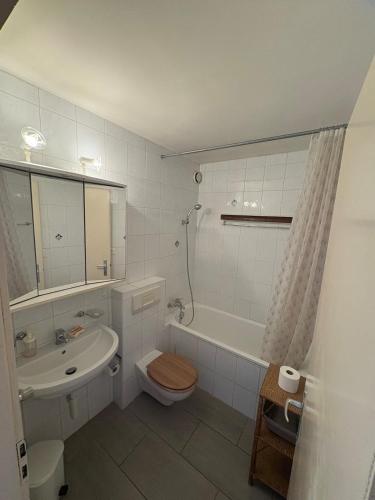 a bathroom with a toilet and a sink and a tub at Cozy studio in Veytaux