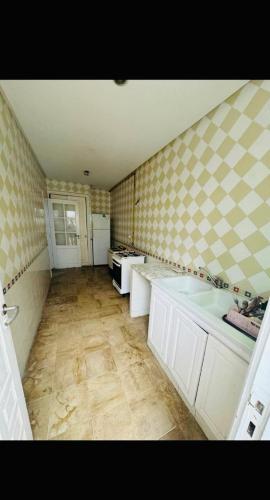 a large kitchen with two sinks and a tub at Appartement rez de jardin in Hammamet