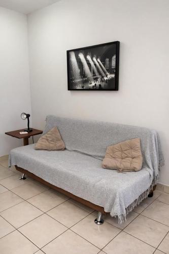 a couch in a room with a picture on the wall at Flat muito bem localizado in Palmas