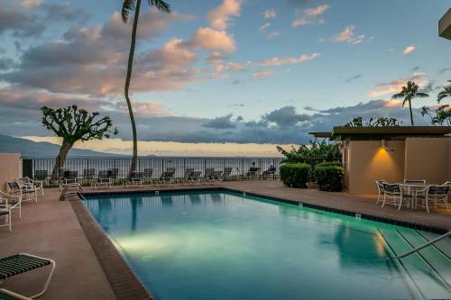 a swimming pool with chairs and a view of the ocean at This place is different!! Award winning! Oceanfront, View View! in Wailuku