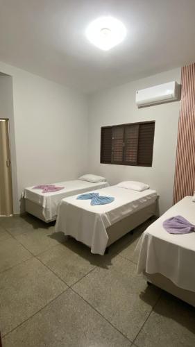 a room with three beds in a room at LD Hotel in Três Lagoas