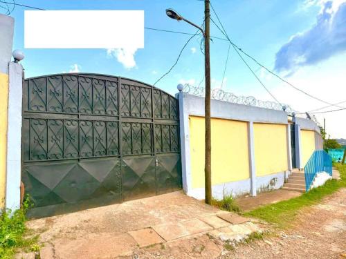 duża metalowa brama przed budynkiem w obiekcie Maison PACHA w mieście Jaunde