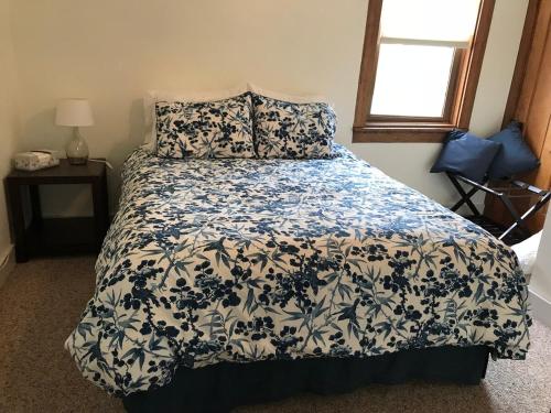 a bedroom with a bed with a blue and white comforter at Wide River Winery Inn in Le Claire