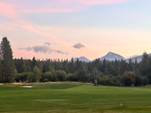 a view of a golf course with mountains in the background at Golf Condo 081 in Black Butte Ranch