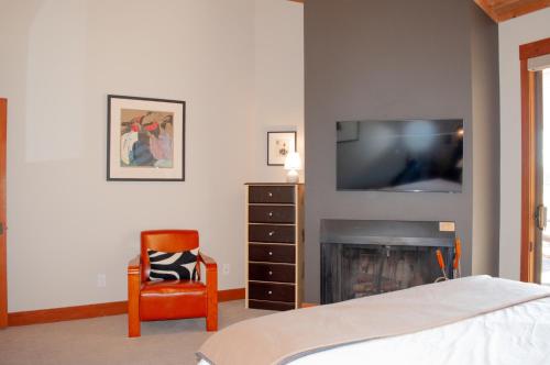 a bedroom with a fireplace with a television and a chair at Lodge Room 015 in Black Butte Ranch