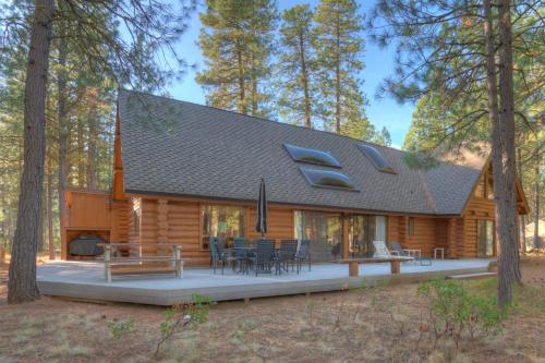 a log cabin in the woods with tables and chairs at Golf Home 105 in Black Butte Ranch