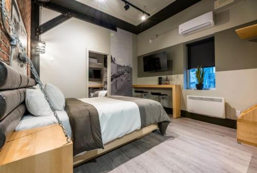 a bedroom with a bed and a television in it at La Suite Hotel in Shawinigan