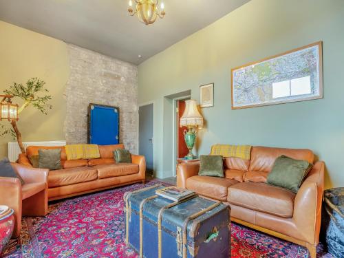 a living room with two leather couches and a rug at Greystonedale Mansion Holiday Retreat in Haltwhistle