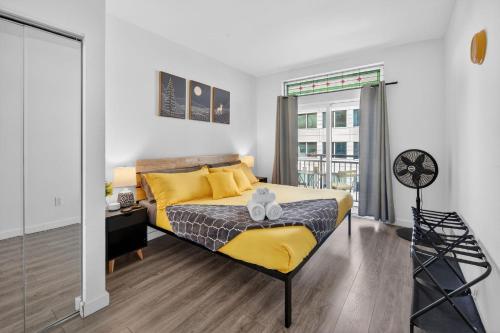 a bedroom with a yellow bed and a window at Vibrant City Gem/99 Walk/Pike Pl/Pool/Pet/Parking in Seattle