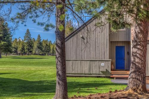 a house with a blue door and trees at Golf Condo 098 in Black Butte Ranch