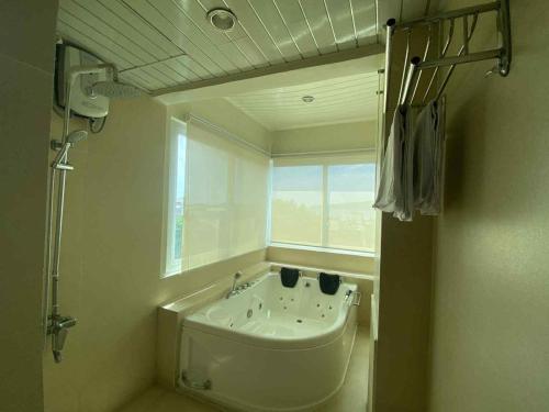 a bathroom with a bath tub and a window at Pagadian Bay Plaza Hotel in Pagadian