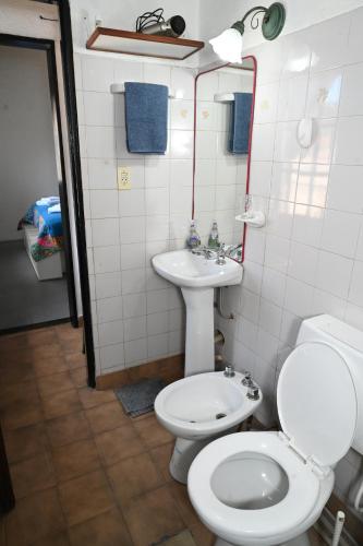 a bathroom with a toilet and a sink at Como en casa in Rawson