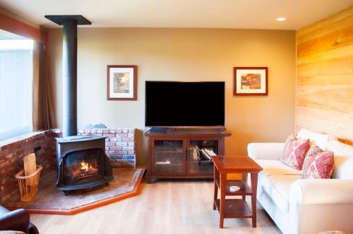 a living room with a fireplace and a flat screen tv at Golf Condo 095 in Black Butte Ranch