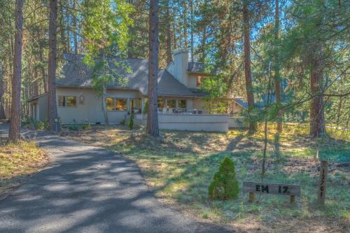 a house in the woods with a driveway at East Meadow 017 in Black Butte Ranch
