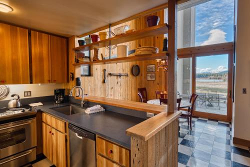 a kitchen with wooden cabinets and a large window at Country House 073 in Black Butte Ranch