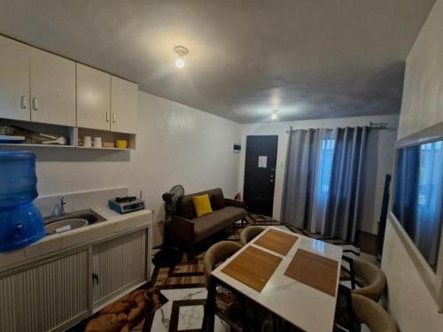 a kitchen and living room with a table and a couch at JO's HOMEtel SL 1 in Sampong