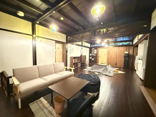 ein Wohnzimmer mit Sofa und Tisch in der Unterkunft ほぼ家 in Tsuruga